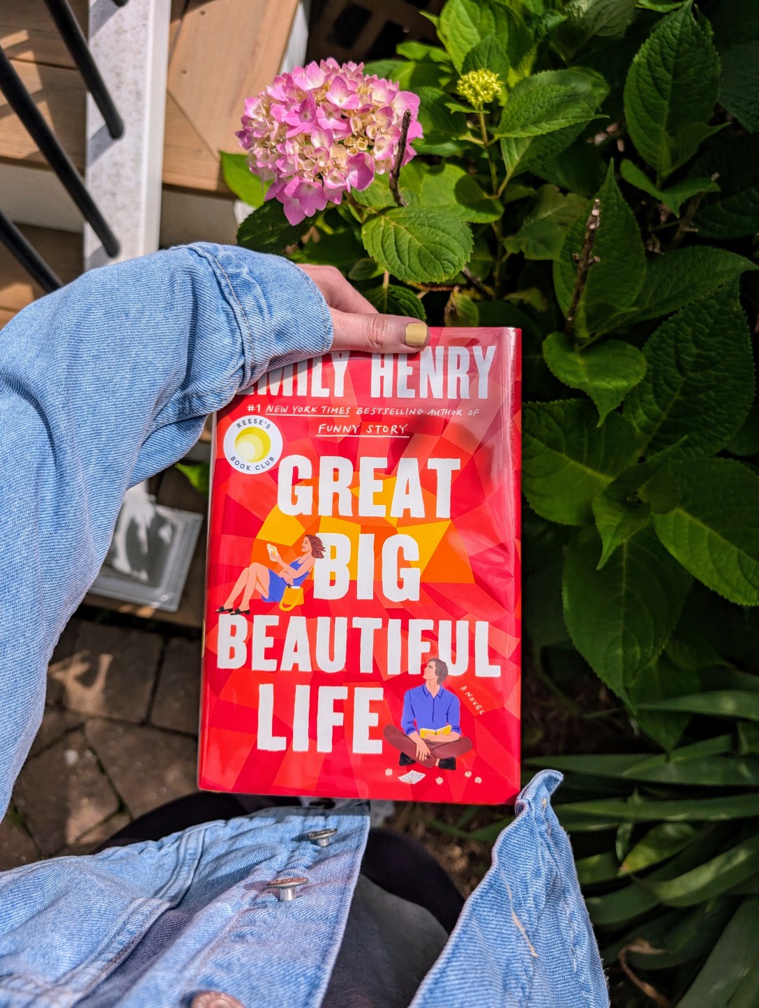 Great Big Beautiful Life held over a pink flower