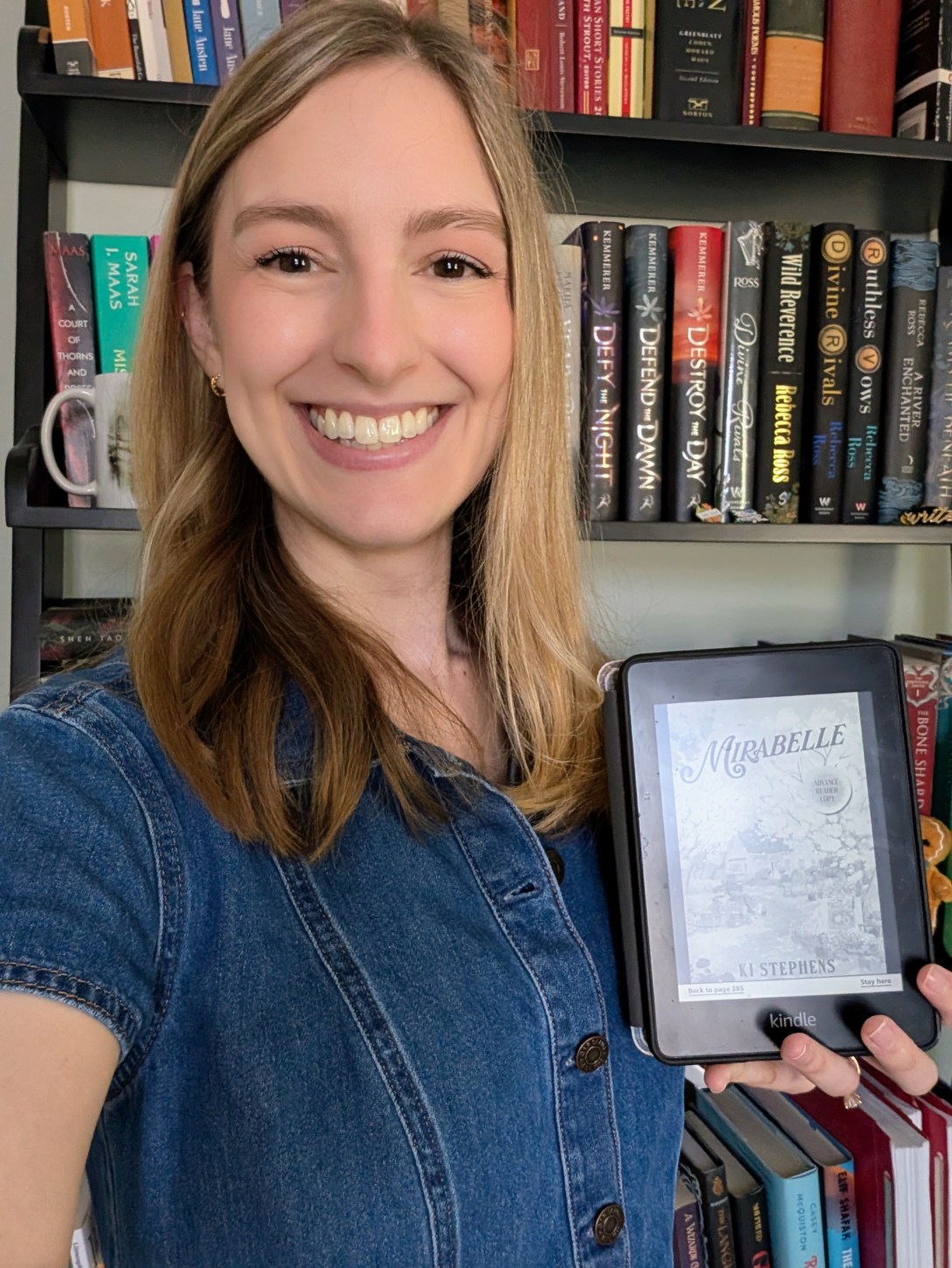 Alexis holding a Kindle ARC copy of Mirabelle